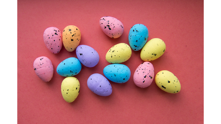 Multi colored Easter eggs on a red pink background.  Happy easter concept.
