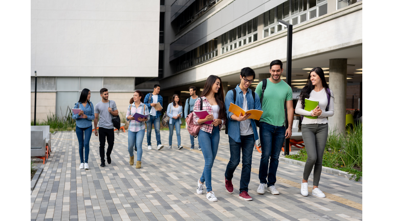 Young latin american students leaving the university campus after a day of class