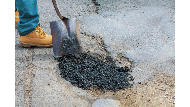 Laying new asphalt, covering the pit, very bad quality road with hole in asphalt