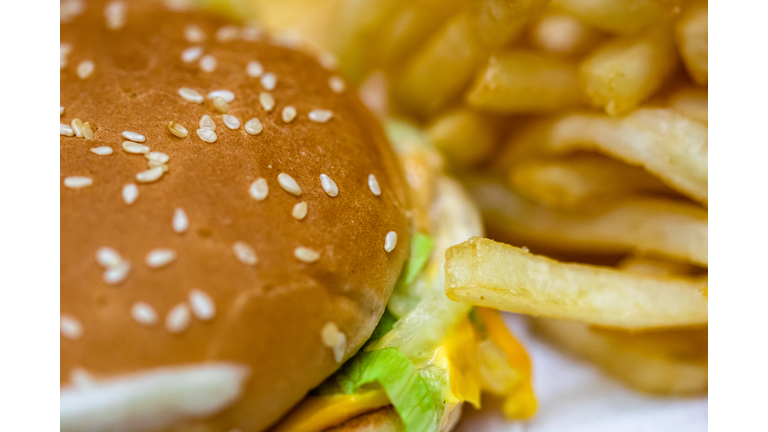 Close up detail of cheeseburger and french fries. Food, junk food and fast food concept