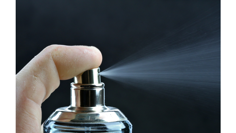 Spray of scented cologne from a perfume bottle