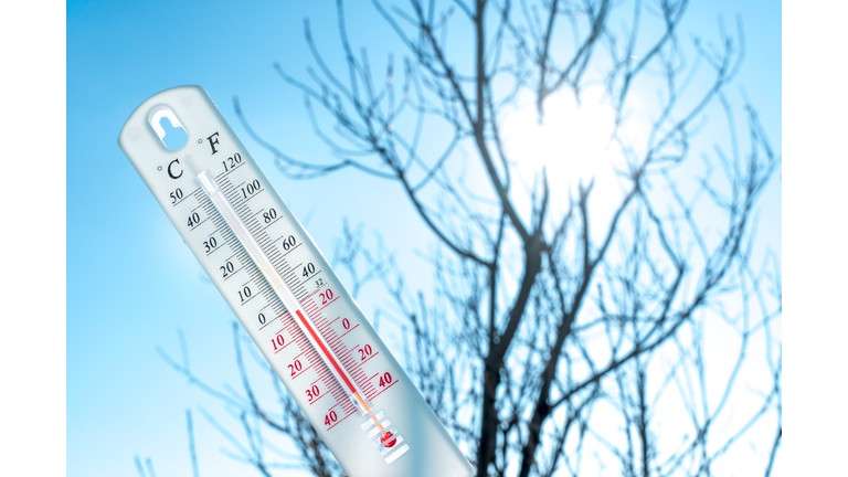 The thermometer lies on the snow and shows a negative temperature in cold weather on the blue sky.Meteorological conditions with low air and ambient temperatures.Climate change and global warming