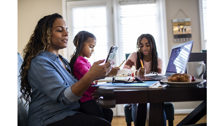 Mother working from home while daughters homeschool