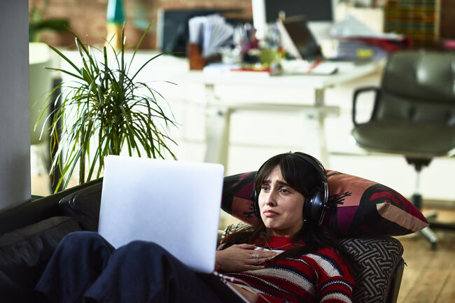 Emotional young woman using laptop and looking upset