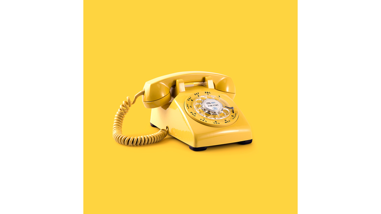 Close-up of yellow telephone against yellow background