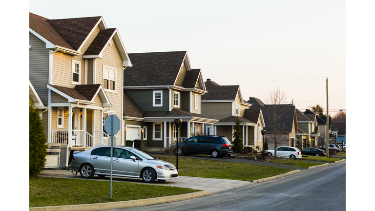 Line of suburb homes each with a car parked in the driveway