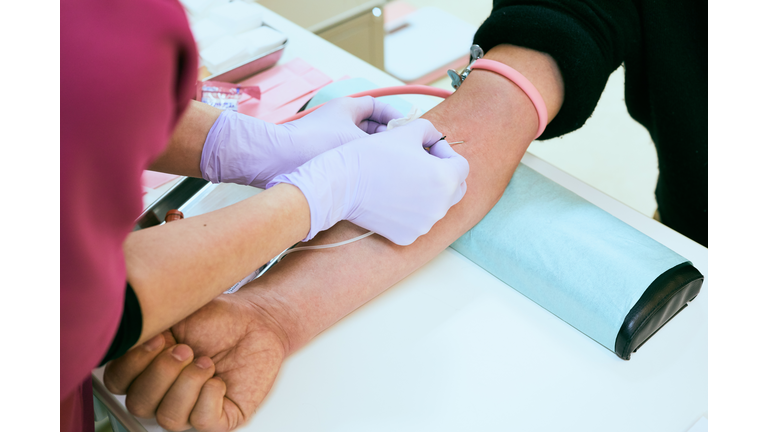 Female nurse is taking blood of a senior patient at Hospital.