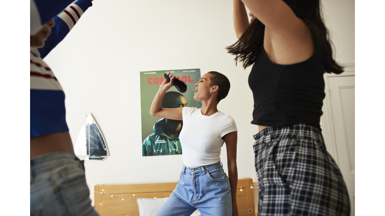Young woman singing and dancing with friends
