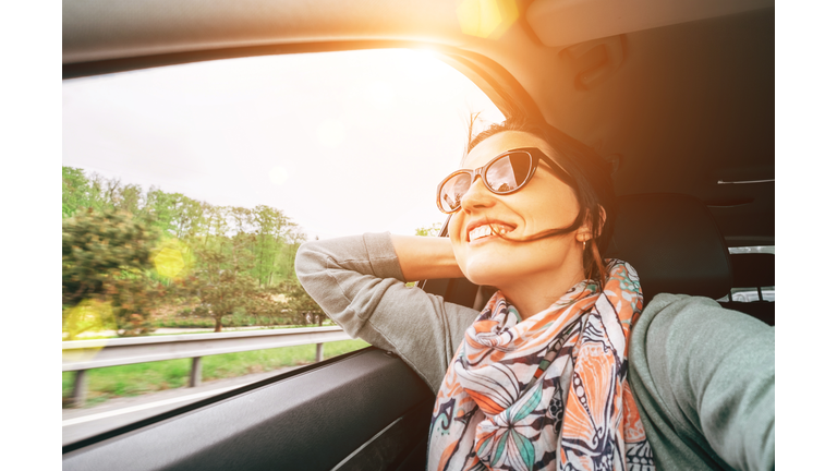 Woman enjoy with view from car window when traveling by auto