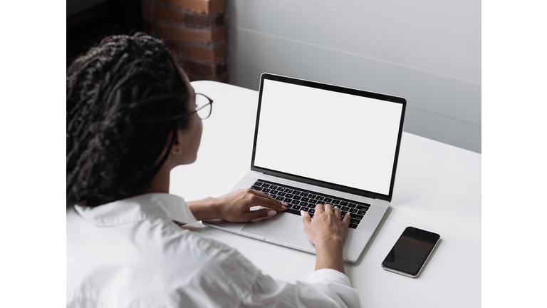 Woman using laptop computer with white blank empty screen mock-up