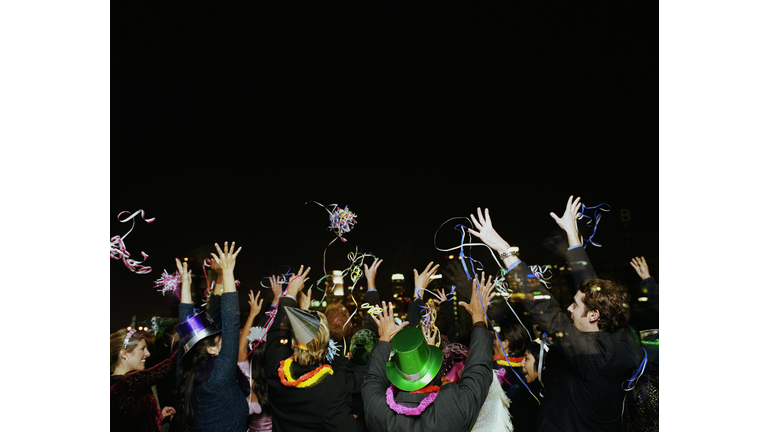 People celebrating on rooftop at New Years Eve party, rear view