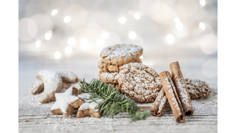 Vegan oatmeal cookies with powdered sugar, cinnamon sticks and cinnamon stars on a wooden table at christmas.