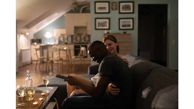 Excited diverse couple watching TV