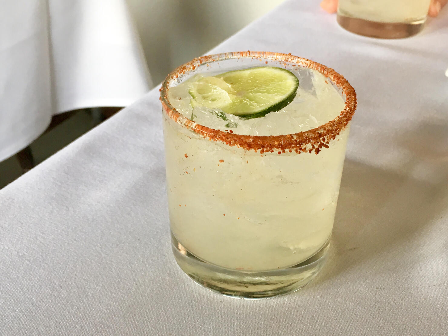 Chili-Salt Rimmed Paloma Cocktail on White Tablecloth