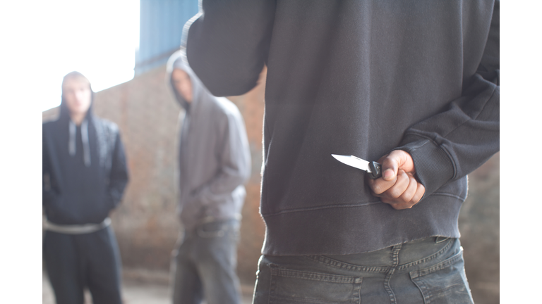 Two men being confronted by man with knife