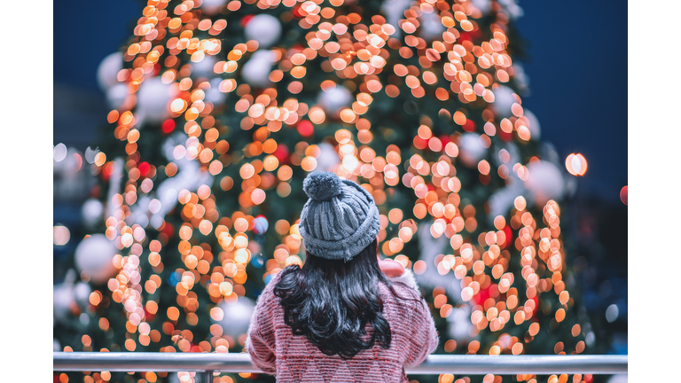 Rear View Of Woman Looking At Illuminated Christmas Lights