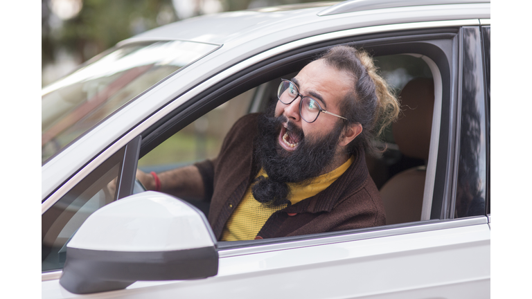 Angry man behind the wheel demonstrating road rage