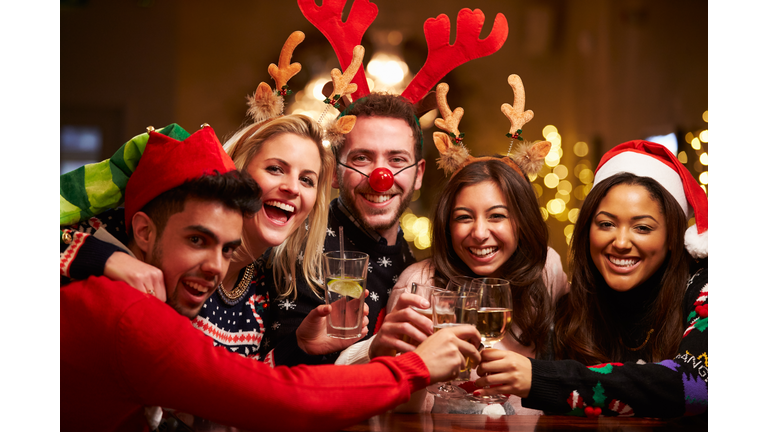Group Of Friends Enjoying Christmas Drinks In Bar