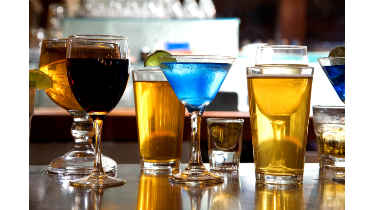 Different alcohol drinks sitting on a bar