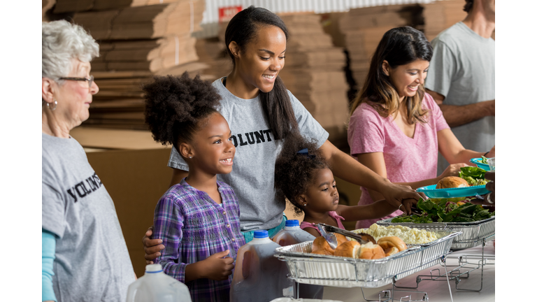 Happy African American family volunteer together in soup kitchen