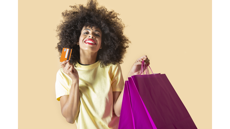 pretty south american woman with shopping bags and credit card, black friday