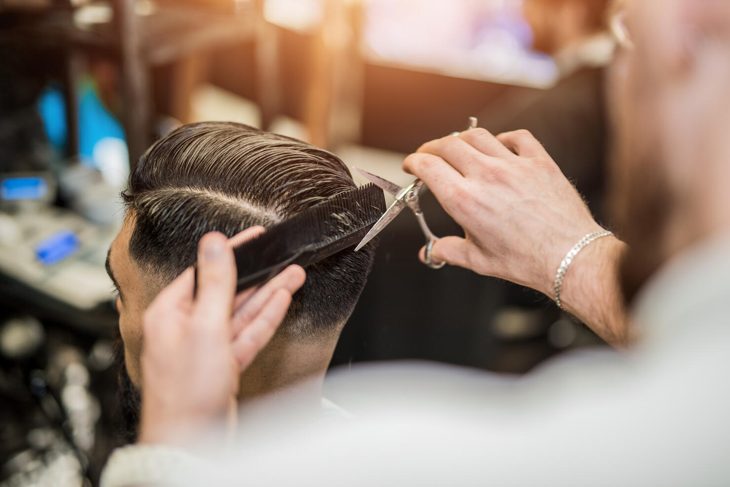 Rear view of young man getting a modern haircut.