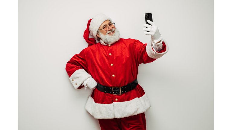 Happy, real, funny Santa Claus taking selfie