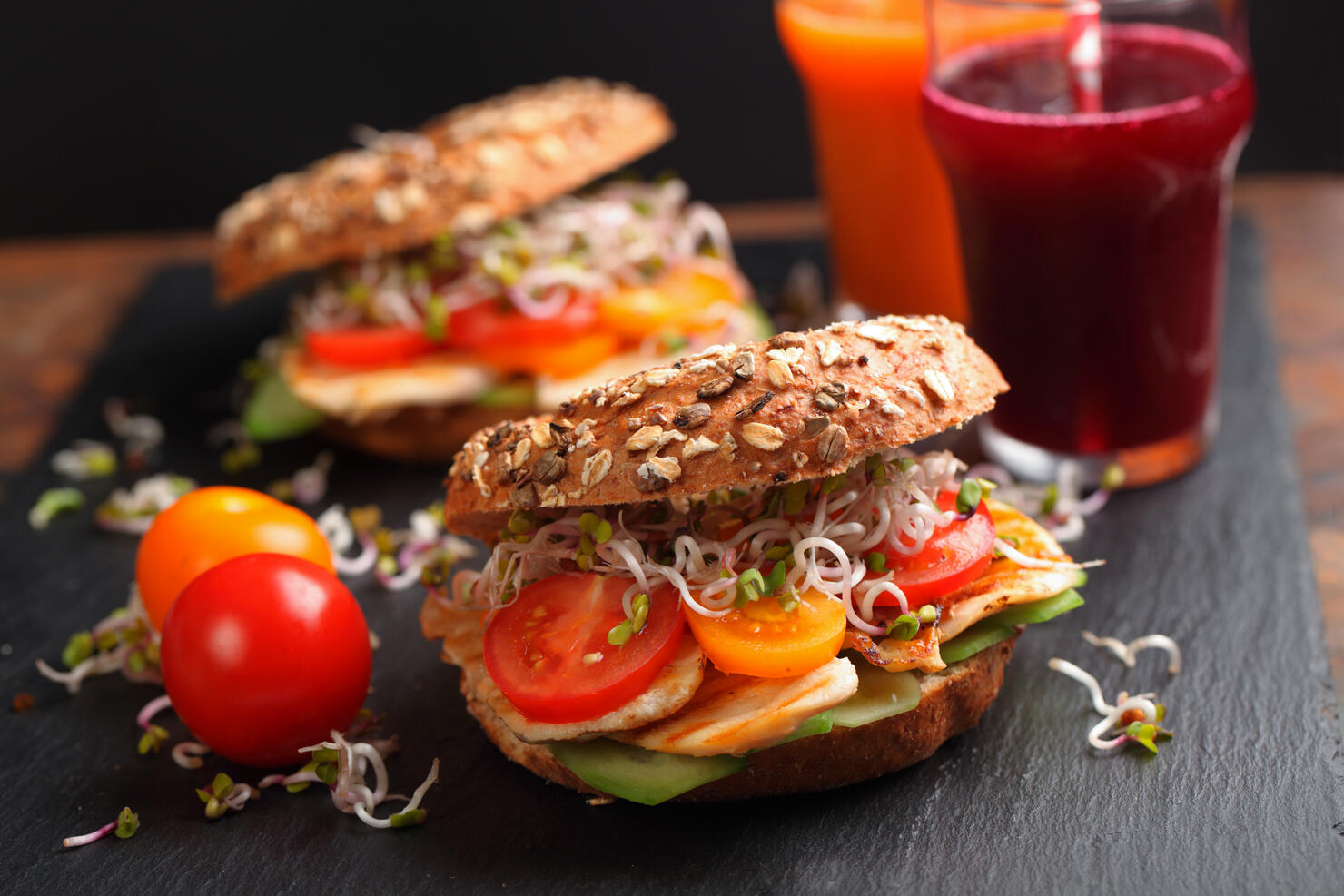 Bagel sandwich with chicken, tomato, radish sprouts, cucumbers and vegetable juices