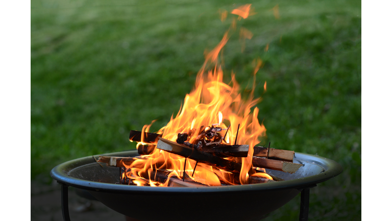 Close up view of a fire pit (fire ring) burning wood on a patio