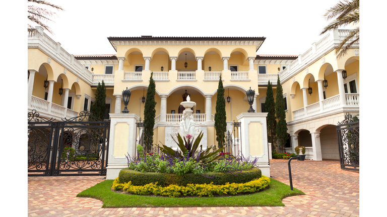 Driveway to luxury two story yellow and White House