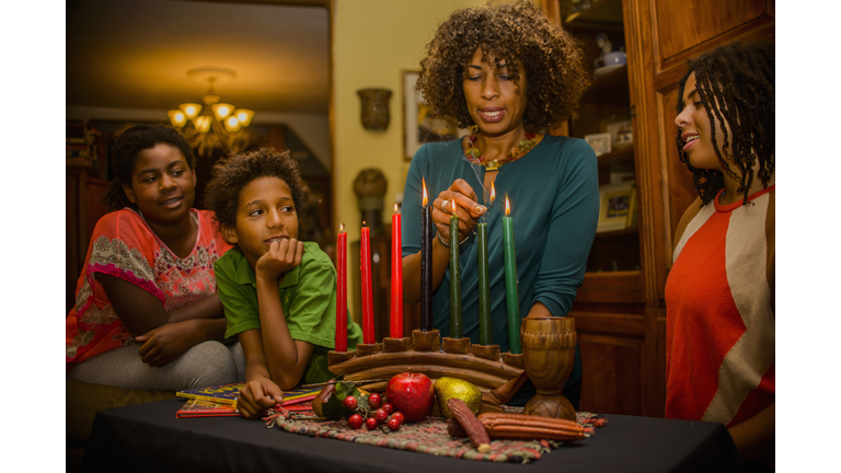 Family lighting kinara candles, celebrating Kwanzaa