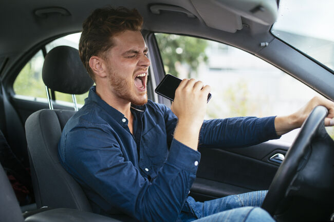 Young man driving and singing