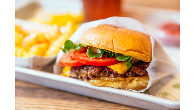 Close up of juicy cheeseburger with fresh tomatoes