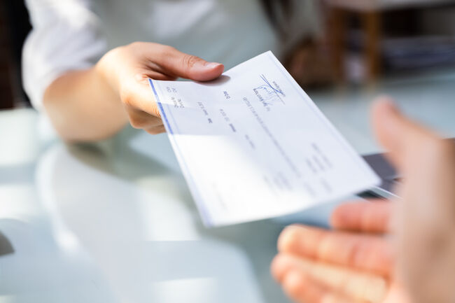 Hand Giving Payroll Compensation Paycheck