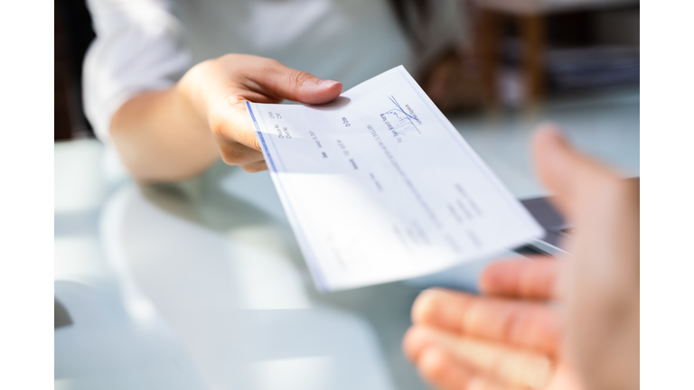 Hand Giving Payroll Compensation Paycheck