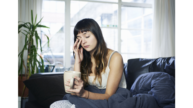 woman looking tired sitting on sofa