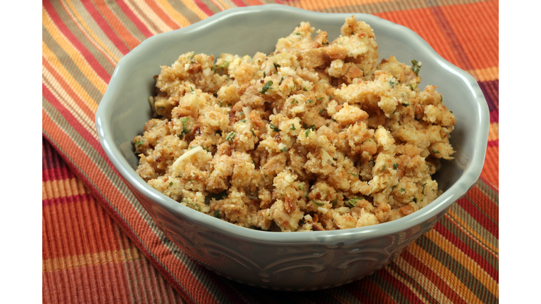White decorative bowl of stuffing on a striped tablecloth
