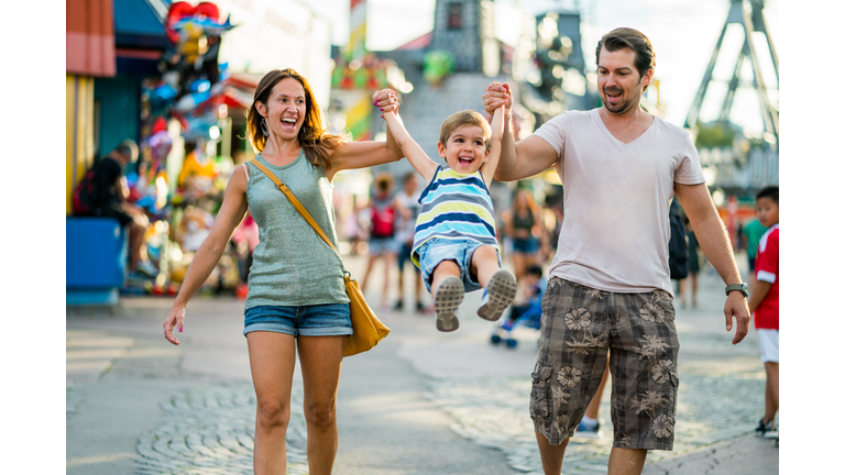 happy family enjoying summer day in amusement park
