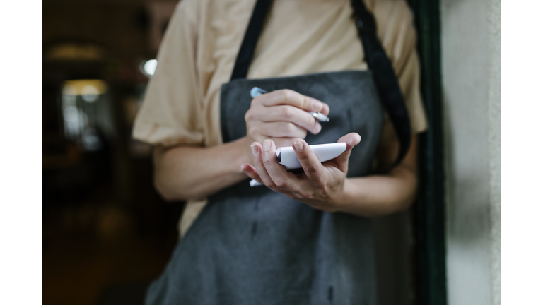 Waitress Writing On Notepad