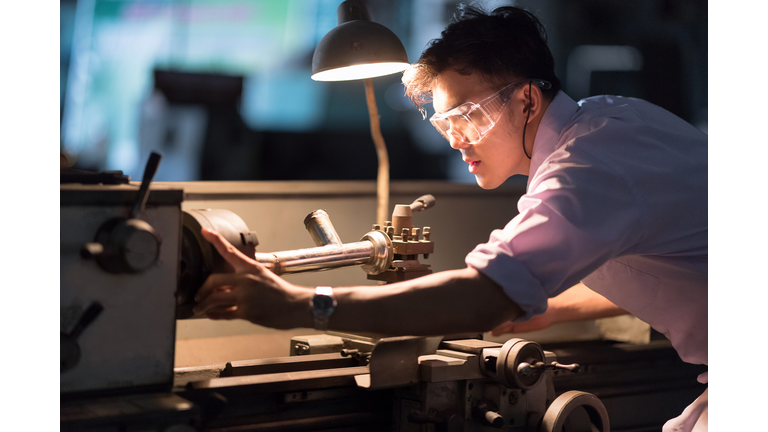 Mechanic Engineer Turner Miller verifies the accuracy of manufacturing steel parts with a scale