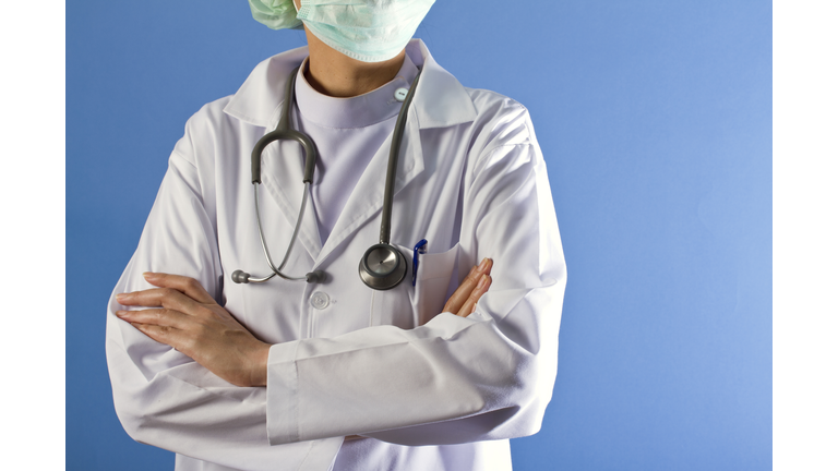 Nurse with arms crossed on blue background