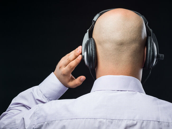 Bald headed man with headphone