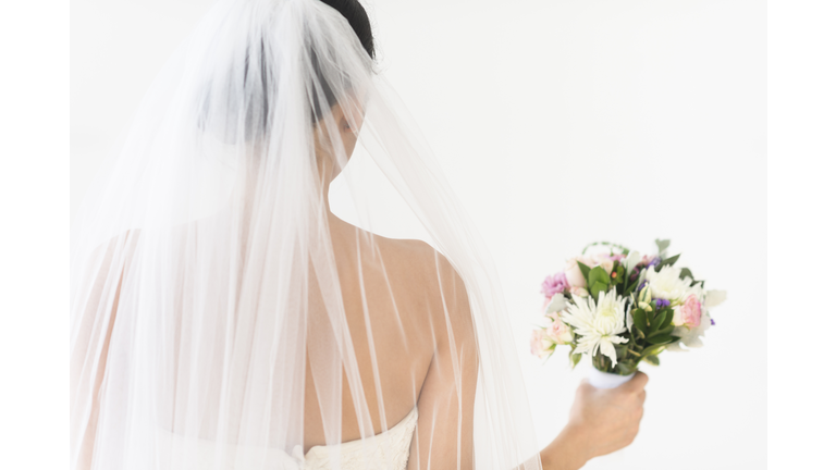 Portrait of bride in veil holding bouquet