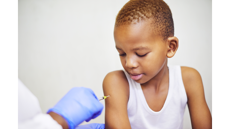 Pupil Receiving Coronavirus Vaccine Injection Sitting With Doctor Indoor
