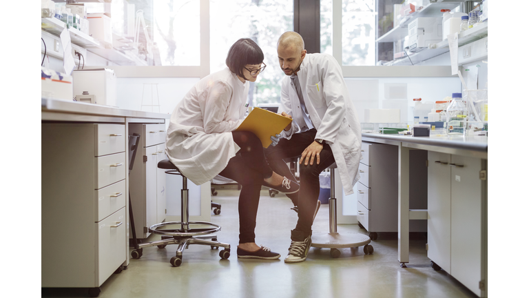 Two scientists inside a laboratory discussing