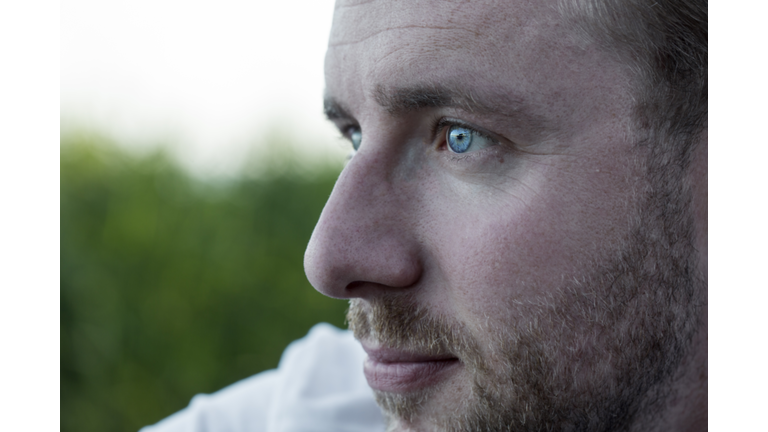 Close-up of young man with blue eyes looking away