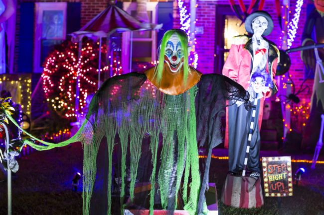 DIY Clown Jack in the box greets trick or treaters in heavily decorated yard