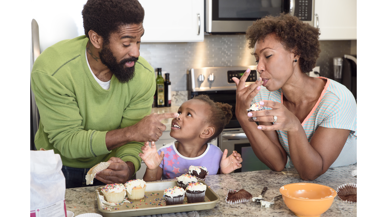 Little girl home baking with her parents