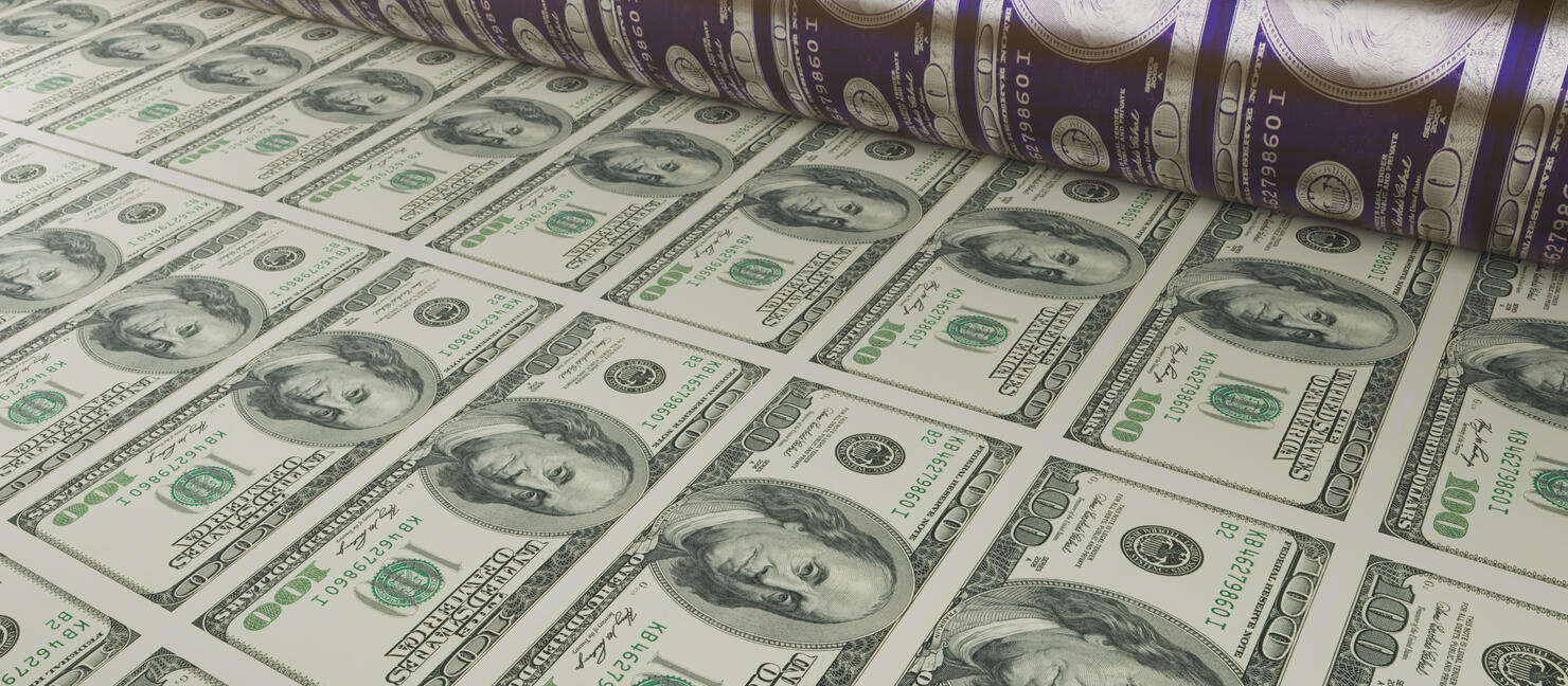 Printing new money. Concept of inflation with 100 dollar banknotes moving towards you from a printing roller.