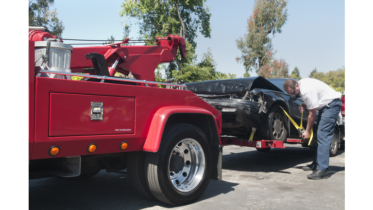 Tow Truck Driver Hauling a Wrecked Car